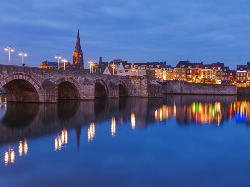 Brücke über dem Wasser im historischen Zentrum von Maastricht am Abend beleuchtet mit stimmungsvollen Lämpchen