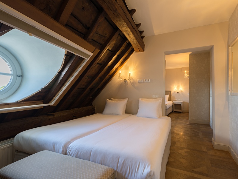 Four-person room in Amrâth Hotel Bigarré ausgestattet mit 4 Einzelbetten mit klassischen Lampen an der Wand